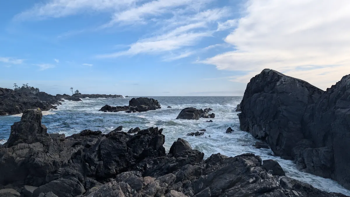 Surf breaking white between black rocks on the Ucluelet coast