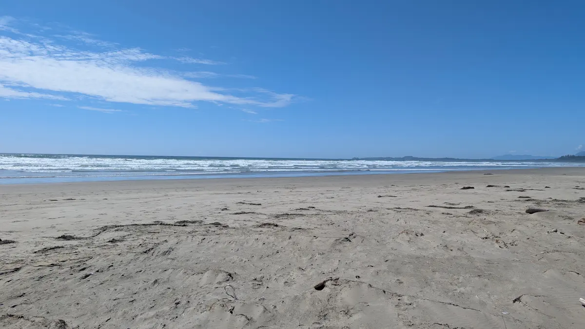 Open sand stretching to the Pacific surf on a clear day